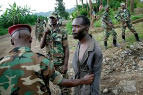 M23 rebels detain a suspected member of an opposing group in Goma
